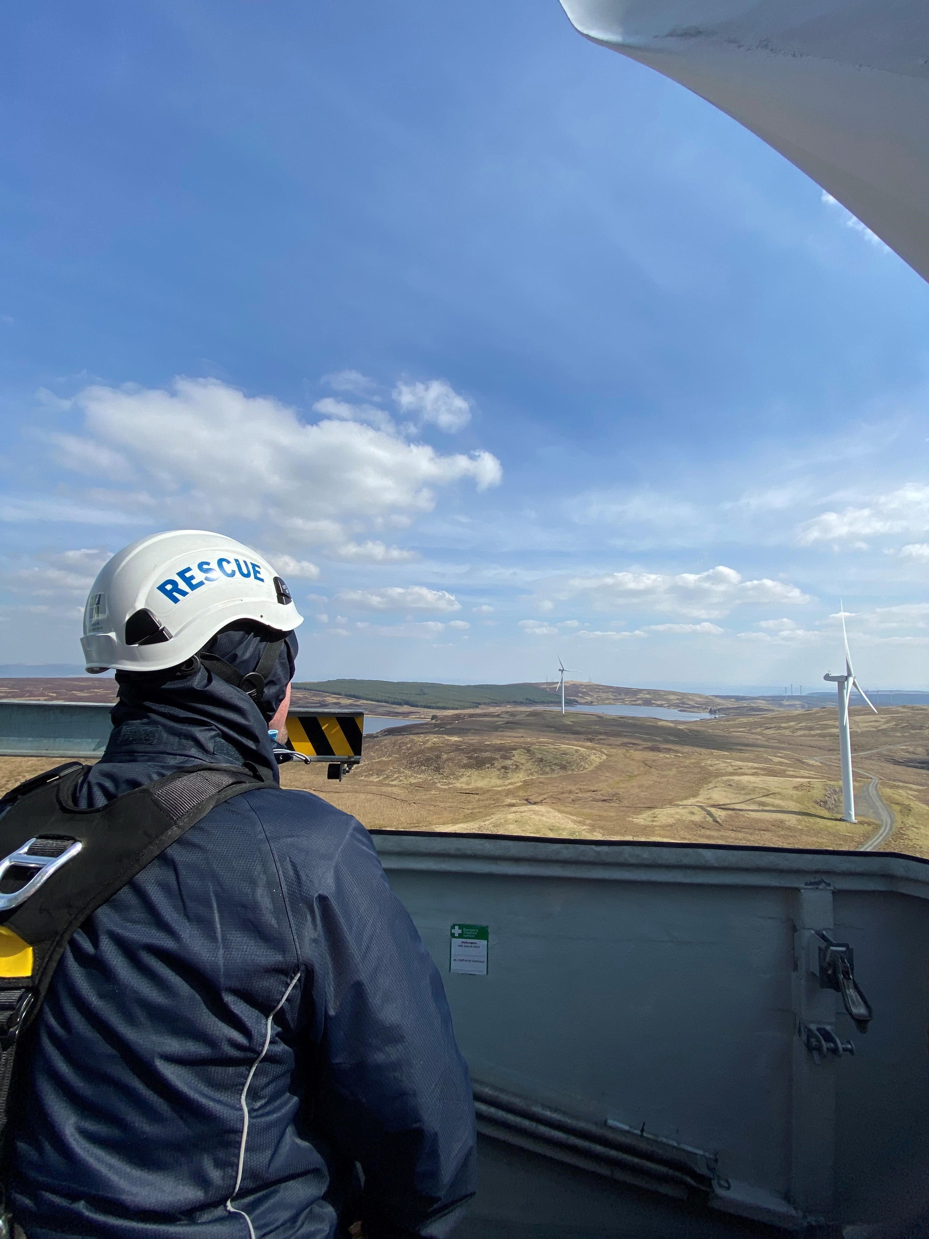 A rescue operator looking at the view from a wind turbine 