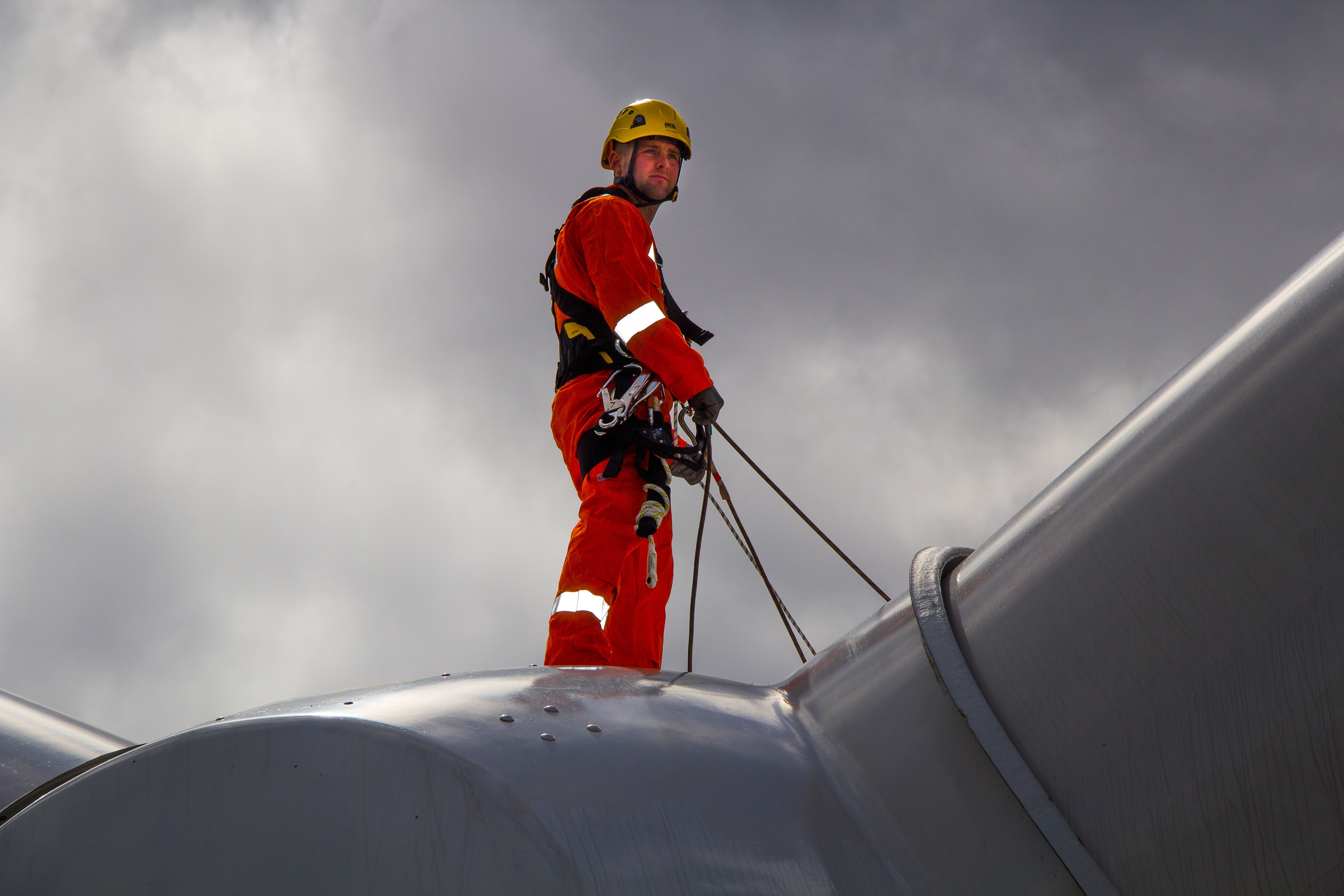 A technician stood on top of a wind turbine 