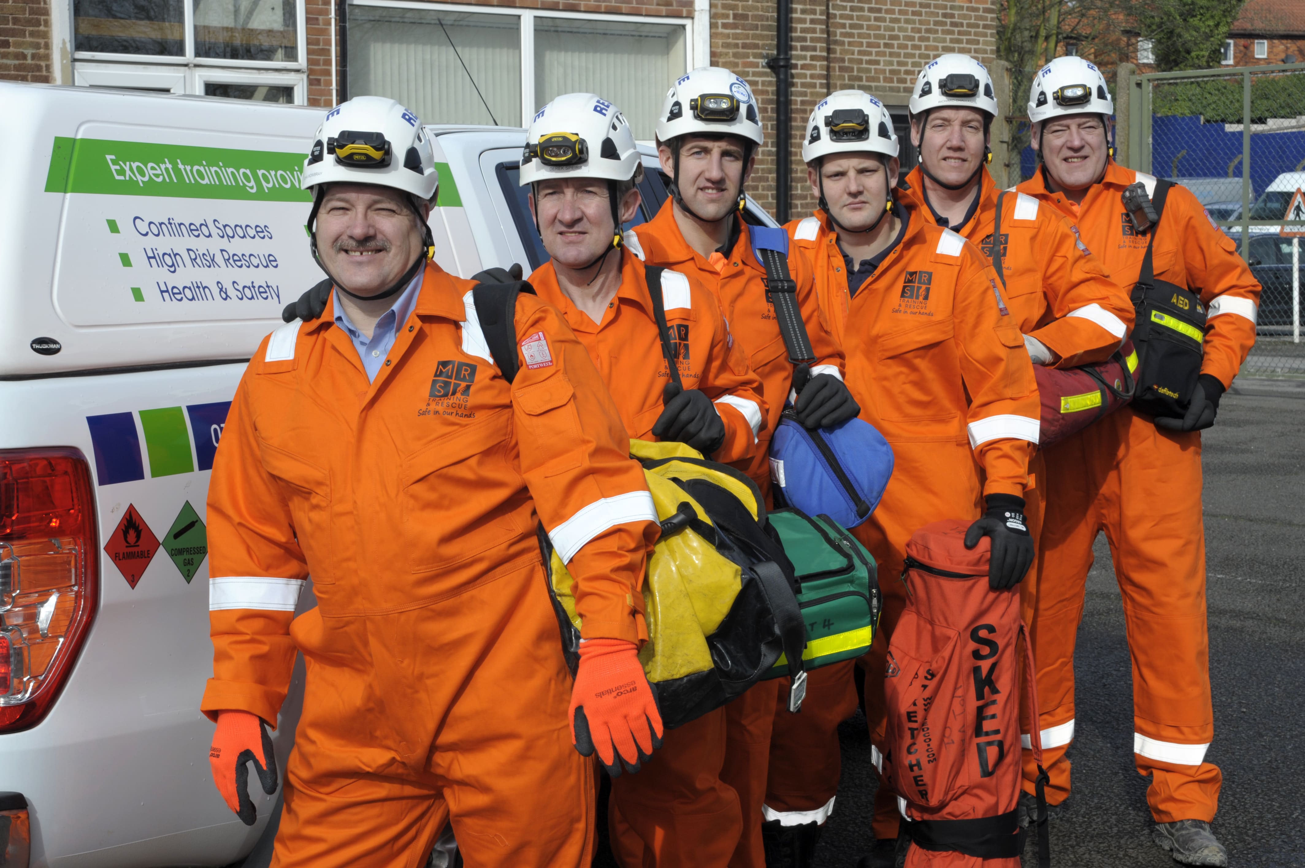 6 MRS Training & Rescue specialists, in uniform with hard hats and emergency rescue equipment
