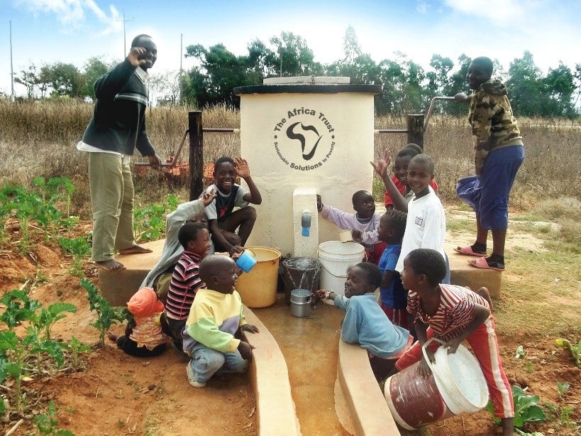 Children and adults using the water pumps