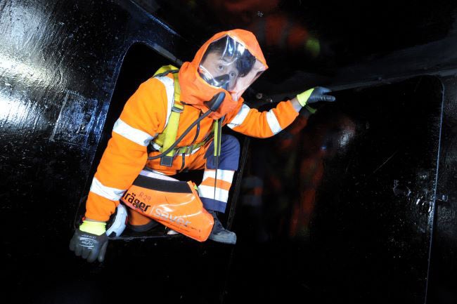 Rescuer escaping a hazardous environment wearing orange high-visibility safety apparel.