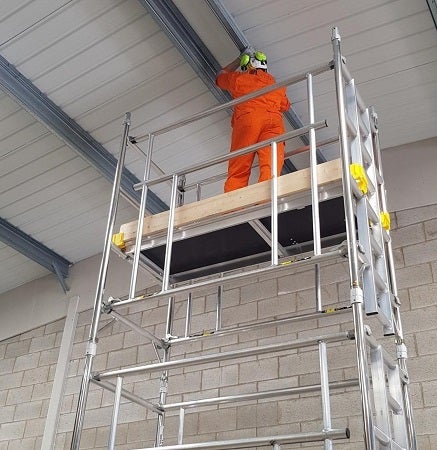 Construction worker in hi vis standing on a 3T (through-the-trapdoor) tower, recommended by PASMA