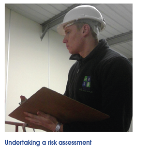 A man wearing a hard hat undertaking a risk assessment