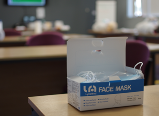 A box of face masks on a desk
