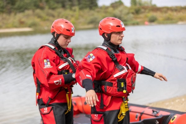 Two Rescue Operatives Wearing Floatation Devices 