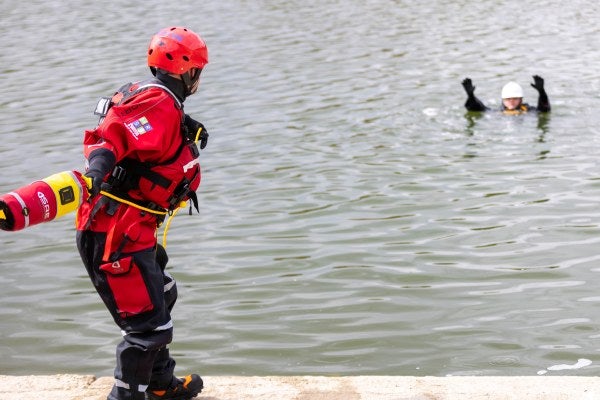 A person throwing a rescue line to a casualty in the water