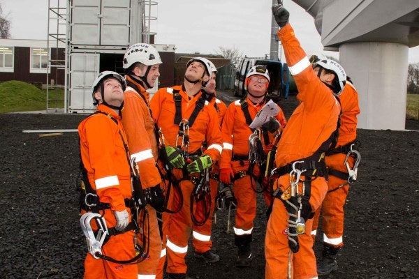 A group of people in high-vis clothing are participating in the Working at Height and Rescue Wind Turbine Training Refresher.
