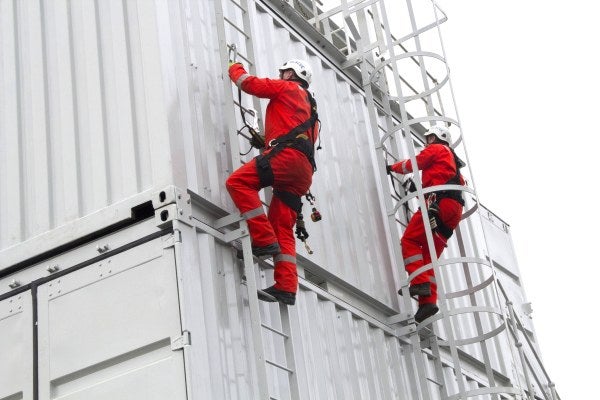 Two men in high-vis clothing and PPE are climbing scaffold as part of the Advanced Working & Rescue From Height Training Course.