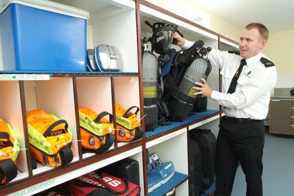 A man in a shirt is looking at the different breathing apparatus equipment for MRS Training 