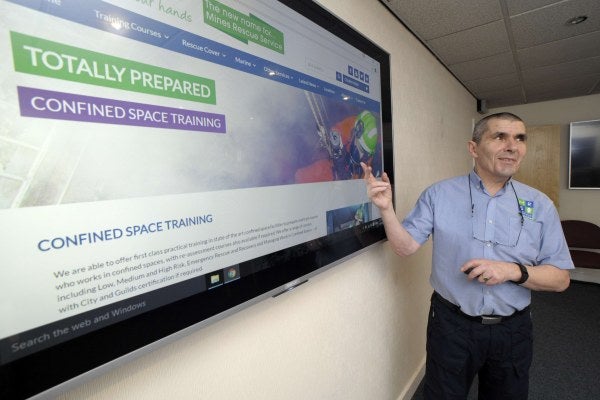 A man pointing at a screen teaching a confined space management session