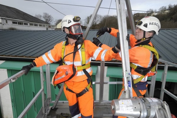 Two men using winch on confined space mobile training unit