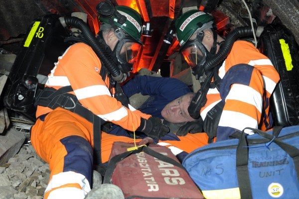Two men carrying out recovery and rescue training in a confined space