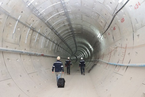 Three men walking through a tunnel as part of the MRS tunneling safety course