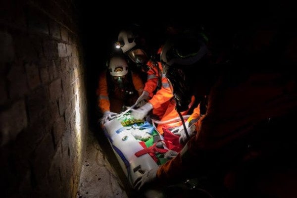 Team using stretcher to rescue casualty in a confined space