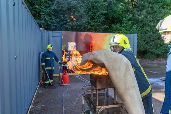 Using a fire blanket during fire training exercises