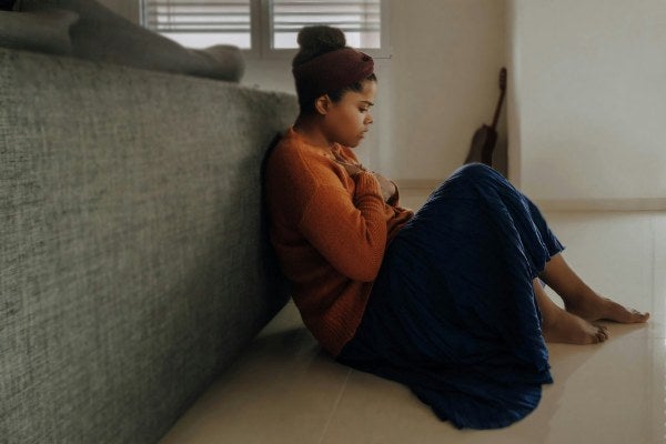 Woman sitting on floor feeling anxious