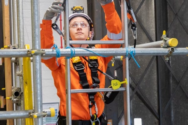 Safely climbing a ladder with work restraint equipment