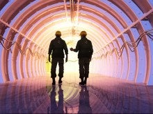 Two men walking into a tunnel